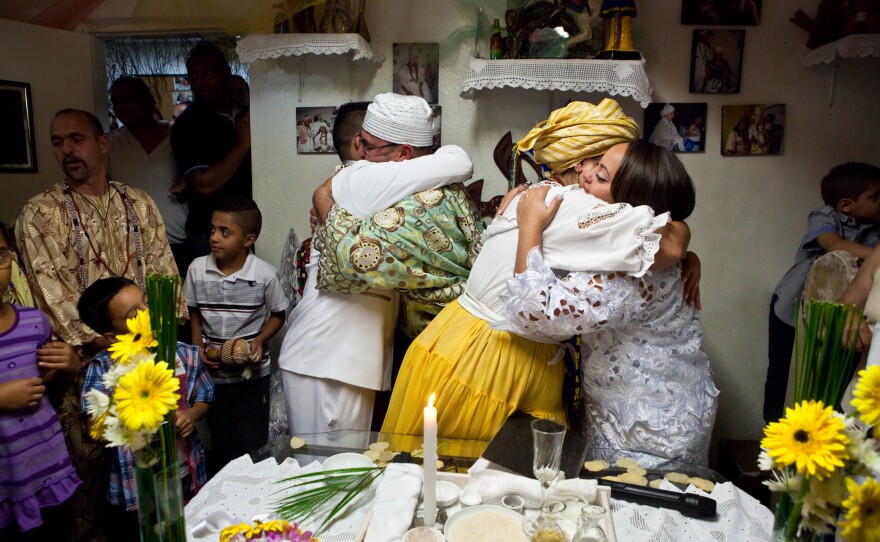 The bride and groom embrace the Candomblé priests after their wedding ceremony.