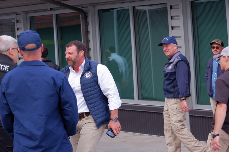 Secretary of Homeland Security Markwayne Mullin shakes hands with a police officer outside of the Kodiak Marketplace on Aug. 11 as Sen. Dan Sullivan walks beside him.