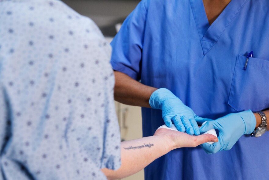 nurse dressing wound on hand