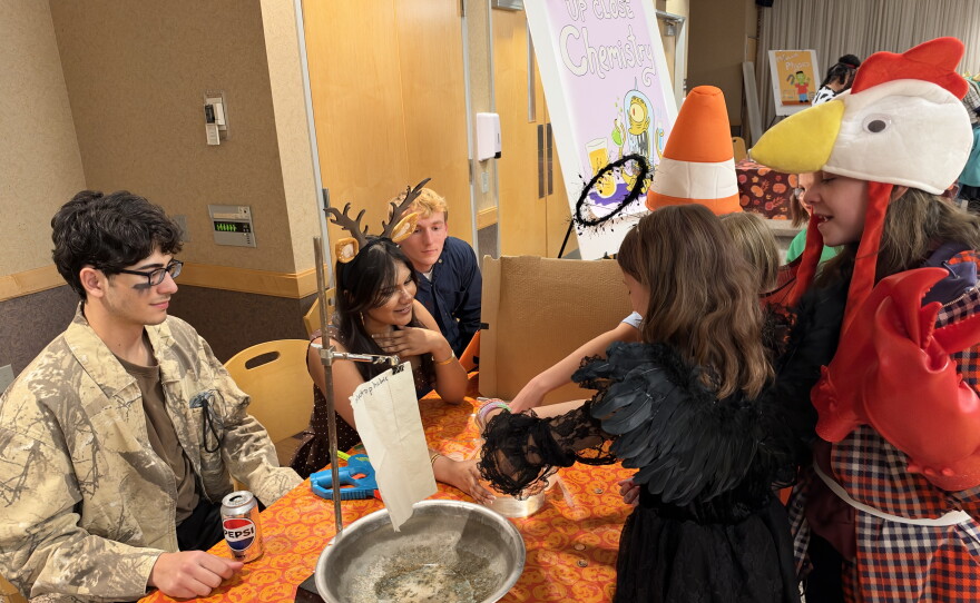 King's College students invite children in Halloween costumes for up-close chemistry.