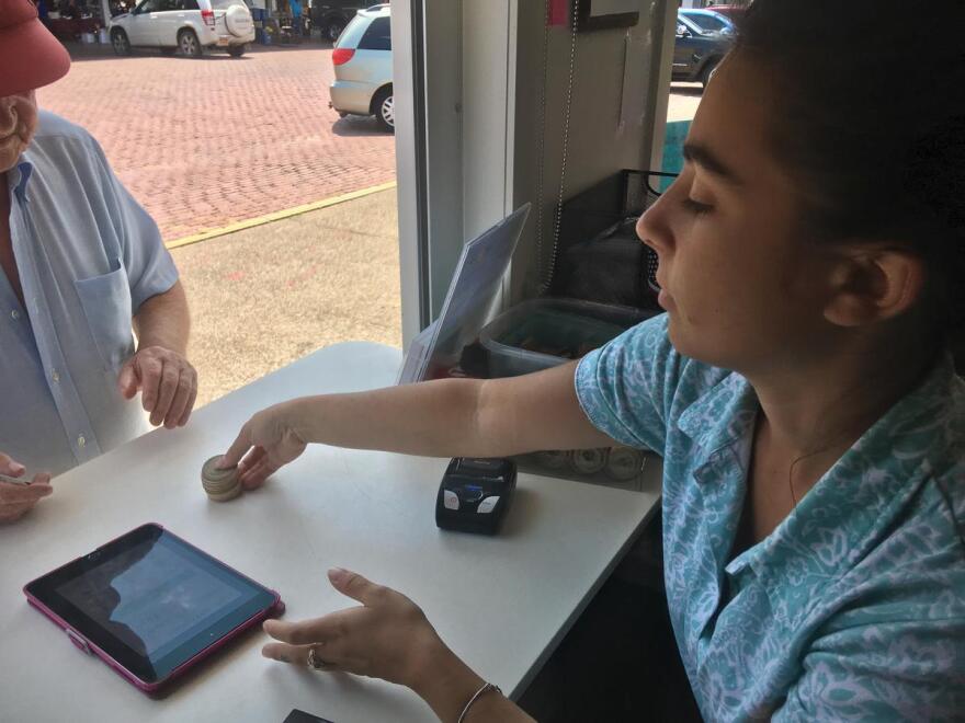 Brittany Touris transfers tokens to a customer using SNAP benefits at the Rochester Public Market CREDIT BRETT DAHLBERG / WXXI NEWS