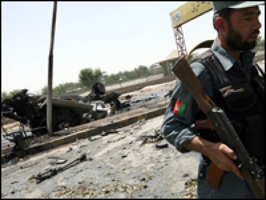 An Afghan National Policeman walks past the remains of a U.S. armored vehicle after it was struck by a suicide car bomber in Jalalabad, Afghanistan.