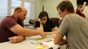 Dave Hutchins (L) and Daniel Hogan look over plans for the cleanup and restoration of the SIlver Bow Creek corridor with Julia Crain, a special projects planner with Butte-Silver Bow county.