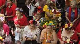 An array of Frida look-alikes lines up by the stage before a promenade across the stage for happy fans and family.