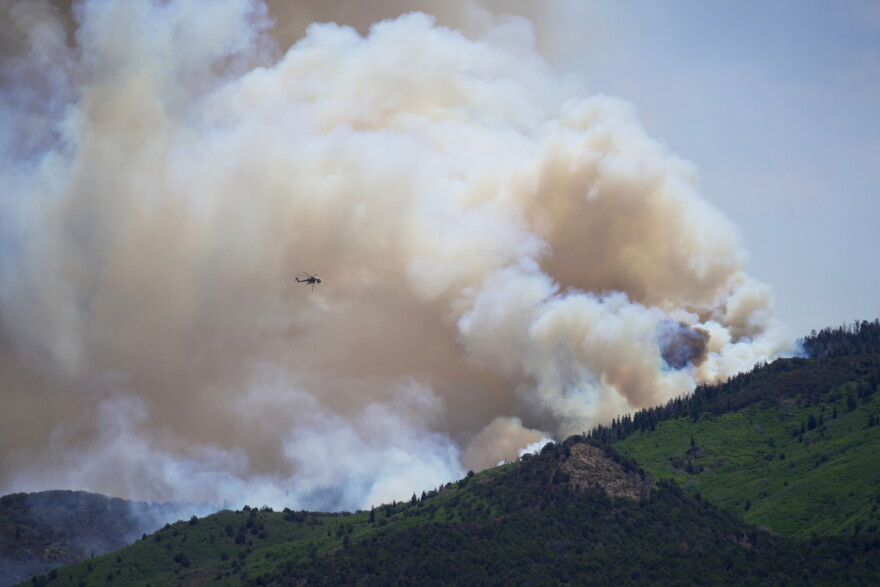 A helicopter flies near the Cottonwood Fire in Beaver, Utah, Tuesday, June 30, 2026. (AP Photo/Ty ONeil)