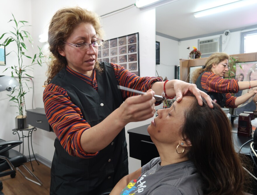 Diana Fuentes, the owner of Salon de Belleza Diana in Chapel Hill, dyes the eyebrows of customer Leticia Lopez.