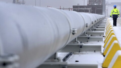 FILE — A worker walks past a gas tube that connects the 'Hoegh Esperanza' Floating Storage and Regasification Unit with main land during the opening of the LNG (liquefied natural gas) terminal in Wilhelmshaven, Germany, Dec. 17, 2022.