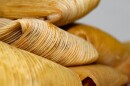 A photo of tamales in husks.