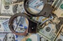Handcuffs lay across US dollars