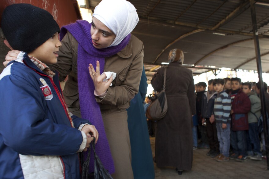 Teacher Rahaf Al Tinawie counsels a student outside class at the Albashayer School for Syrian Refugee Children. Al Tinawie says many children show signs of trauma and she sometimes meets with parents to discuss the problems the children are facing.