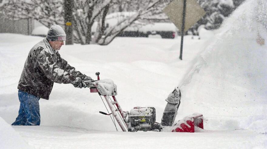 Darrell Chesley clears the snow from his driveway on Sunday in Wellsville.