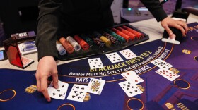 William Eary, a table games dealer at Harrah's Casino, shuffles a deck of cards at the casino in Chandler, Okla., Wednesday, Aug. 5, 2026. (AP Photo/Brittany Bendabout)