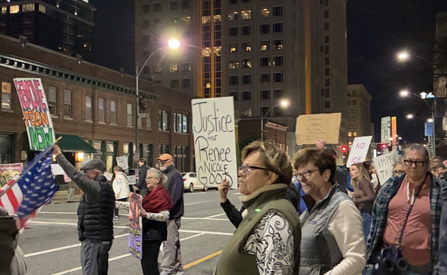 Protesters gather along Market Street in Greensboro holding signs in protest of a fatal ICE shooting 