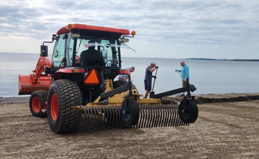 A group of volunteers work to remove debris from the Thunder Bay at Blair Street Pier in Alpena on Wednesday, July 29, 2026.