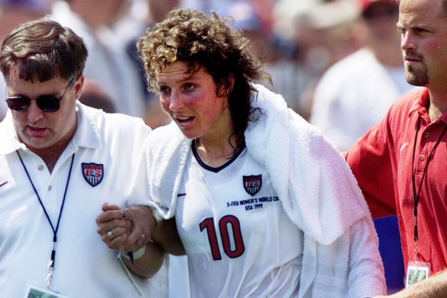 Michelle Akers, center, is helped off the field by the training staff after taking a hard hit in the second half of the Women's World Cup Final against China at the Rose Bowl in Pasadena, Calif., on July 10, 1999.