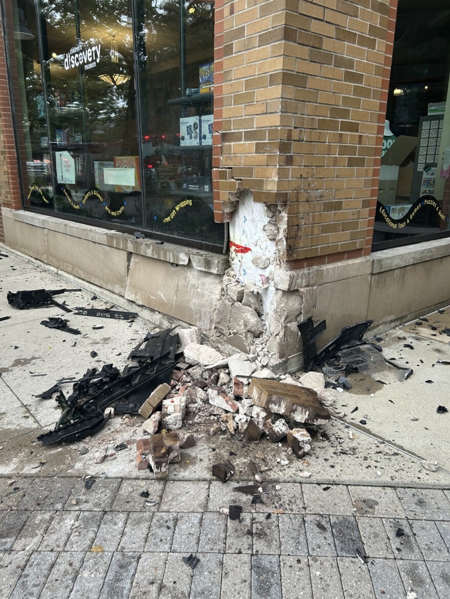 A children's museum's exterior is shown damaged with bricks and concrete spilling on to the sidewalk