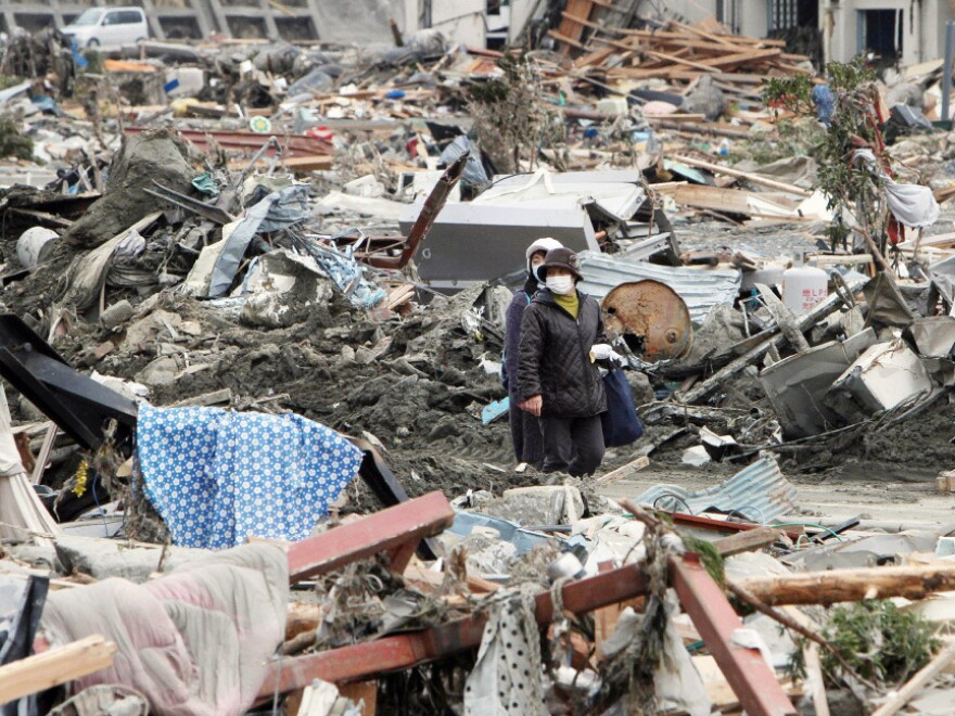 People walked through rubble in Minami-Sanrikucho, Miyagi prefecture, earlier today (March 15, 2011).