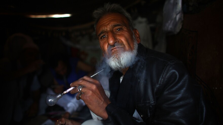 A self-proclaimed poet and scholar, Haji Ismatullah blows smoke out after taking a hit of crystal meth. He says he turned to drugs after his wife and kids were killed in a car accident.