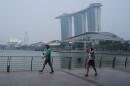 People exercise along the Marina Bay waterfront promenade as the Marina Bay Sands resort is shrouded in transboundary haze from fires in Indonesia, pushing the city’s air quality back into the unhealthy range, Monday, Sept. 14, 2026 in Singapore.