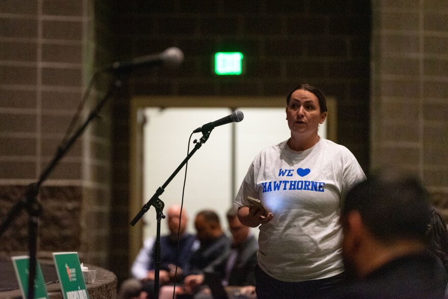 A Hawthorne Elementary parent addresses the Salt Lake City School board in a shirt that says “We heart Hawthorne.” Many Hawthorne families showed up to the Dec. 5 hearing at West High School in these shirts.