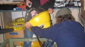 MBARI Engineer Paul McGill dismantles the electronics module that connects to the seafloor seismometer.