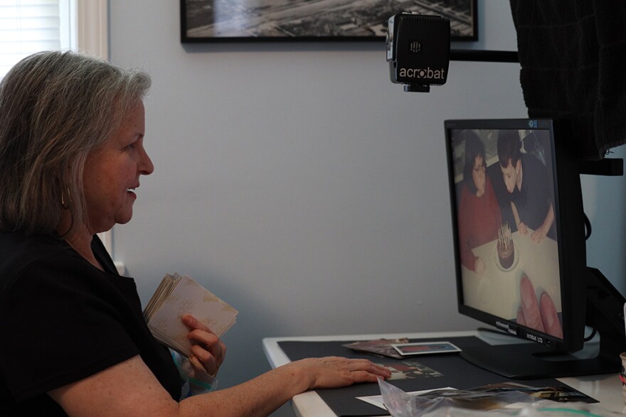 Patty Starr uses a magnifier to edit and digitize family photos -- a project that helps her cope with being at home for days at a time.