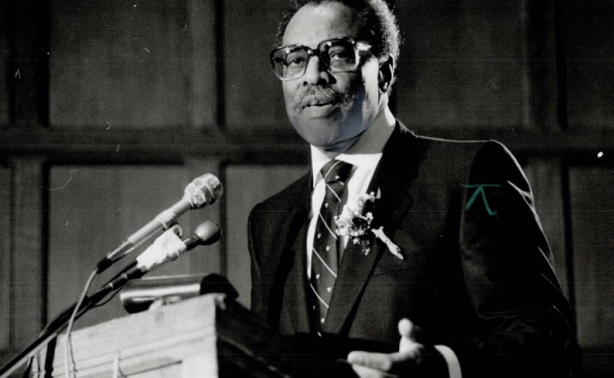 Lincoln Alexander, a man wearing glasses, speaks at podium