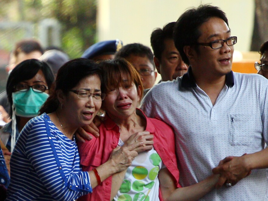 Relatives of Juanita Limantara, one of the victims of the AirAsia Flight QZ8501 crash, weep during the handover of her body to the family at a police hospital in Surabaya today.