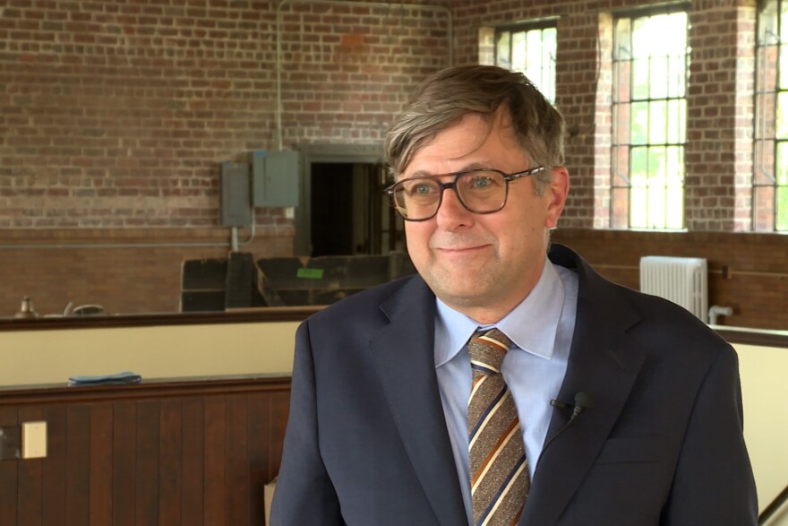 A middle aged man in a suit with glasses