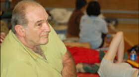 Lexon Faulk sits with evacuees at a Red Cross disaster relief center in Austin. He drove his family from Port Arthur, Texas.