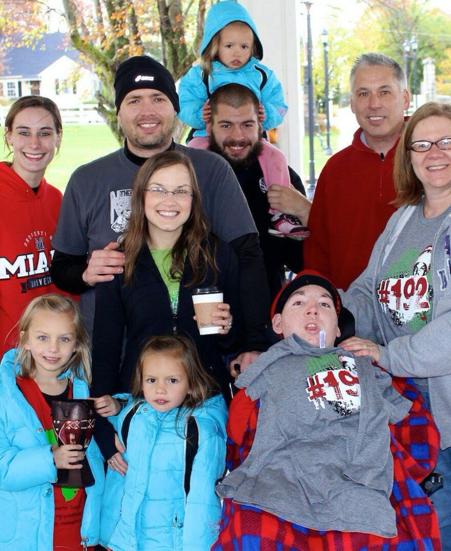 Craig Minor (red shirt, right) poses with his family.