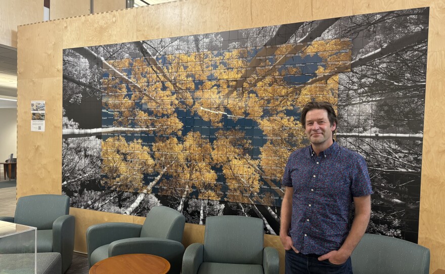 Photgrpaher Mark Maziarz stands with one of his pieces on display at the Park City Library April 29, 2026. Maziarz has been a Parkite since the 1990s, working in portrait, commercial, and fine art photography.