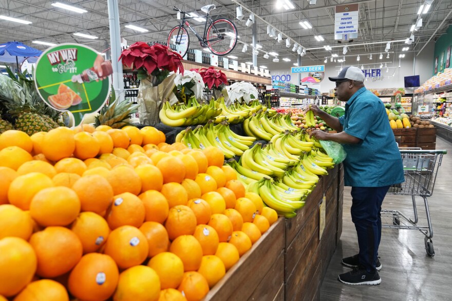 A customer shops for bananas at the Price Choice supermarket on Friday, Nov. 14, 2025, in Miami.