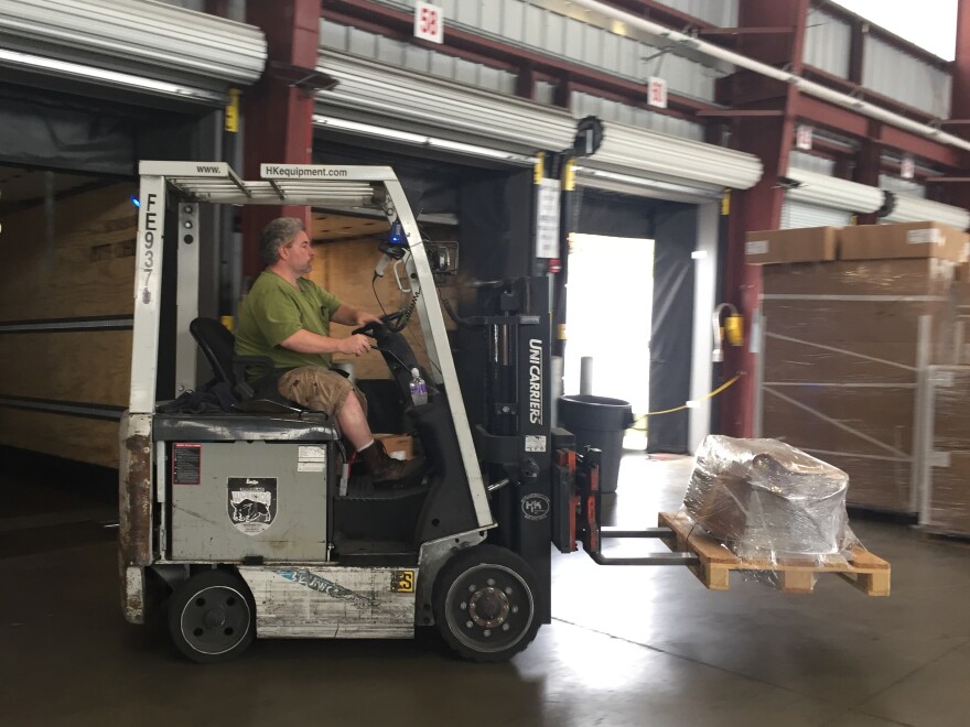 Gene Lutz drives an electric fork lift powered by renewable energy at Pitt Ohio, a trucking company with an office in Harmar, Pa. The firm has invested in solar and wind energy, along with a bank of storage batteries, to create an independent microgrid that would hold up in a storm. Researchers hope to build more of these and link them together to create a reliable backup supply.