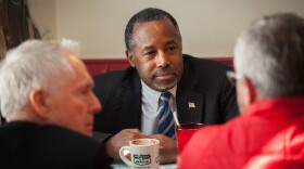 Republican presidential candidate Ben Carson has coffee with staff members during a campaign stop at The Airport Diner in Manchester, N.H.