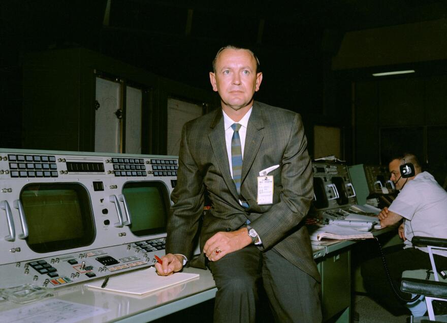 Kraft is seen at his flight director console in the Mission Control Center.