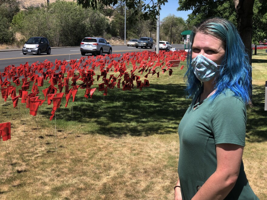 Leola Reeves has set up more than 8,000 red flags, each one with a black silhouette, to represent COVID-19 cases in Yakima County, Wash.