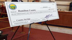 A giant ceremonial check represents the recovered money.
