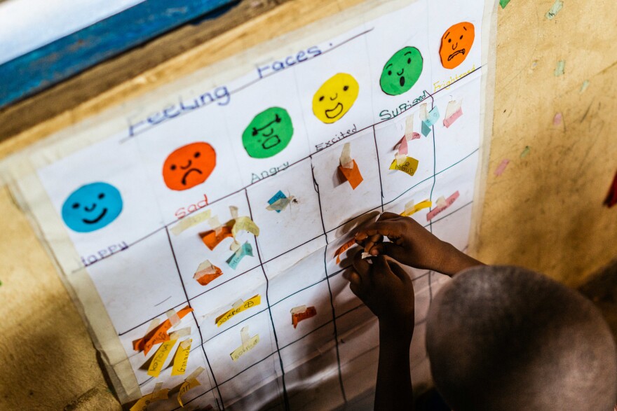 Every day, Gbetodeme asks her students to put a sticker under the face that reflects their mood. Then she asks them why they're feeling that way — one of many ways she tries to draw the children out in open-ended conversations.