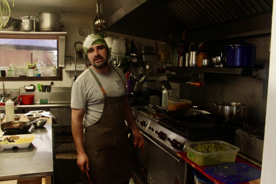 The owner of Falafelove, Avishai Leibson, cooks chicken, falafel, and other treats inside the restaurant's kitchen.
