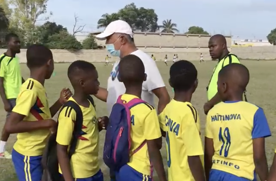 FONDAPS founder Patrice Millet (in facemask) greets Haitian boys before a soccer game in Port-au-Prince