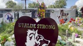 Posters, flowers and portraits fill the lawn in front of Robb Elementary School in Uvalde, Texas, on Sept. 6, 2022, a part of a memorial after a gunman killed 19 students and two teachers at the school on May 24, 2022 (AP Photo/Lekan Oyekanmi)