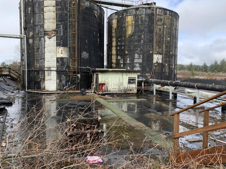 Two large, rusted towers on a waterlogged site. 