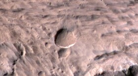 A photograph of the new crater (large, center). Take by the Mars Reconnaissance Orbiter's High Resolution Imaging Science Experiment.