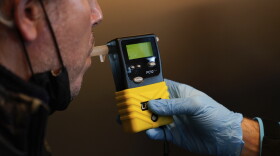 A video journalist takes a breathalyzer test.
