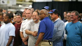 Wil James, center foreground, president of the Georgetown Toyota plant, shook hands with team members before a live webcast last month to introduce the redesigned 2012 Camry. After four years away from Georgetown, James is glad to be back at the plant.