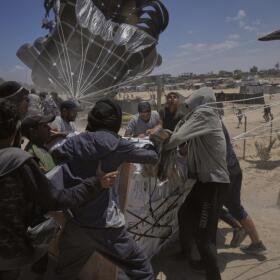 Palestinians rush to collect humanitarian aid airdropped by parachutes into Deir al-Balah, central Gaza Strip, Tuesday, Aug. 5, 2025. (Abdel Kareem Hana/AP)