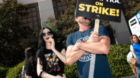 Actress Kristen Ritter (L) walks among SAG AFTRA members at the picket line outside of Warner Brothers in Burbank, California.