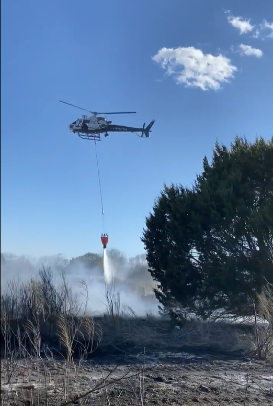 The SAPD helicopter "Eagle" dumps water on a grass fire near Talley Road this week.png