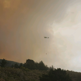 A helicopter carrying water to the Plaskett Fire.